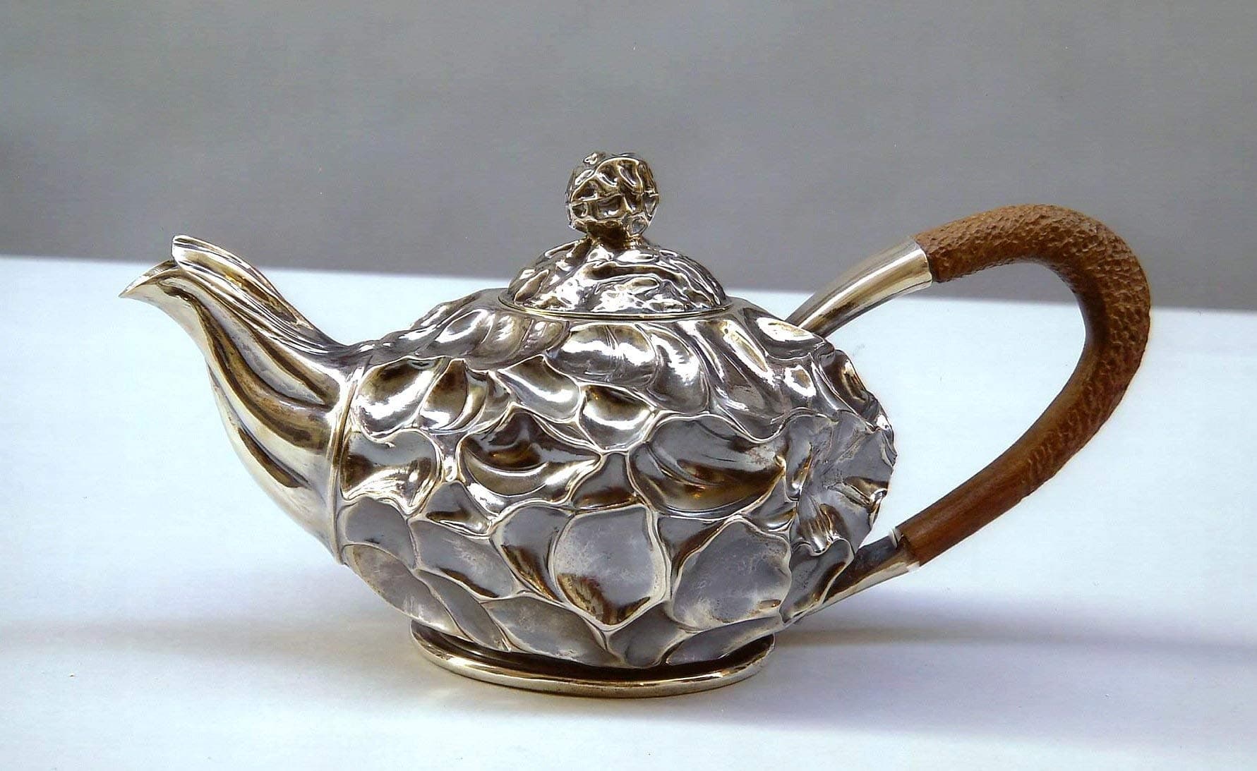 Teapot: silver plate turned, embossed and chiseled by hand The handle and the knob of the lid are made of wood working